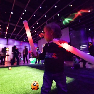 Child Playing with Light Sabers at Baby Rave Event