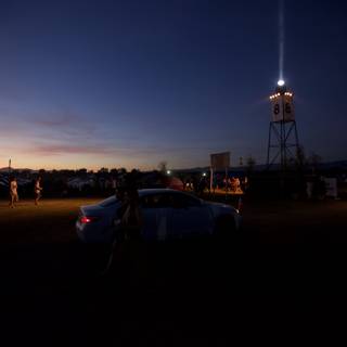 Parked Car by Light Tower at Dusk
