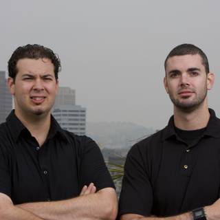 Two Happy Men in Black Shirts Enjoying Cityscape View