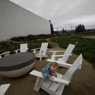 Toddler Playing Among Modern White Adirondack Chairs