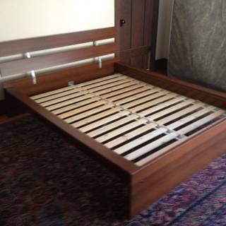 A Stained Hardwood Bed Frame with Slats