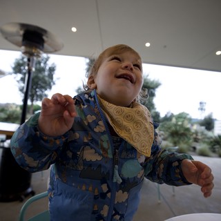 Joyful Toddler in Dinosaur Jacket at Outdoor Restaurant