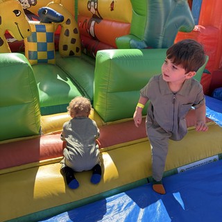 Two Boys Playing on Colorful Inflatable Bounce House
