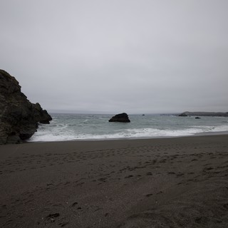 Moody Overcast Cove with Dark Volcanic Sand Beach
