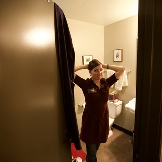 Woman Fixing Hair in Bathroom Doorway Portrait