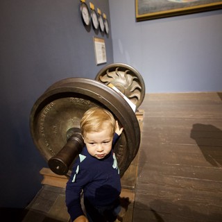 Toddler Exploring Vintage Naval Cannon at Museum