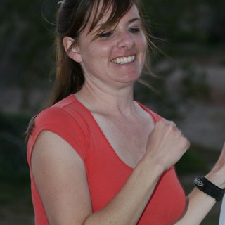 Joyful Woman in Red Laughing Outdoors at Dusk