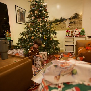 Child Unwrapping Presents on Christmas Morning 2025
