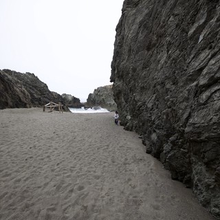 Child Dwarfed by Towering Sea Cliffs at Hidden Cove