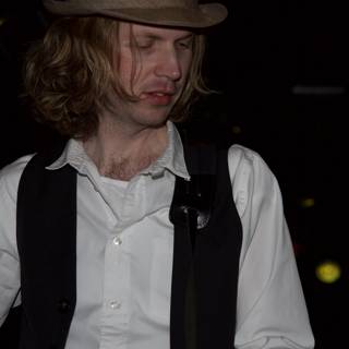 Beck Strums His Guitar in Fedora and Vest