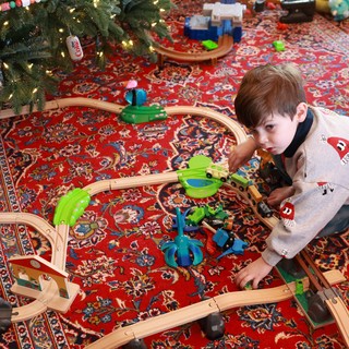 Boy Playing with Wooden Train Set on Christmas Morning
