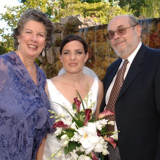 Bride Poses with Parents at Outdoor Wedding Ceremony