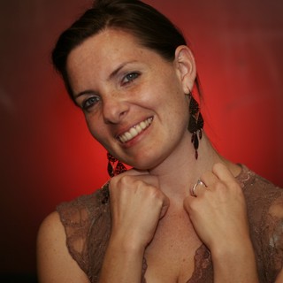 Smiling Woman in Lace Dress Against Red Background