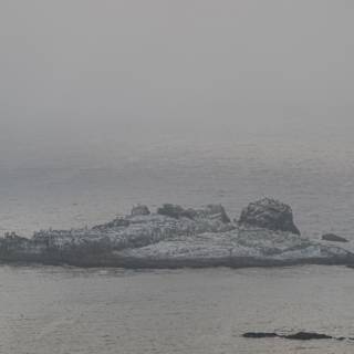Solitary Rock in the Misty Ocean
