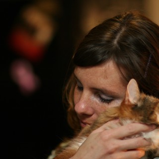 Tender Moment: Woman Embracing Her Calico Cat