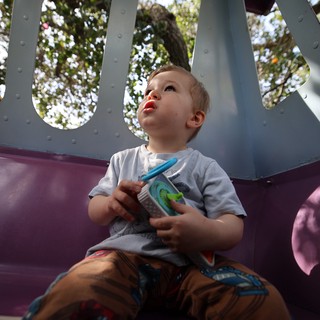 Young Child's Wonder on Playground Slide