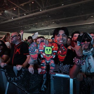 Smiling Fan Holds Pixel Art Figure at Wobbleland 2026