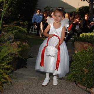 Little Girl in a White Dress Strolls Down a Garden Path