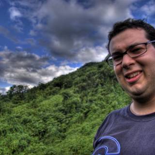 Smiling Man with Glasses in front of Majestic Mountain