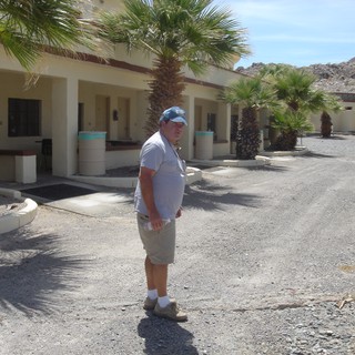 Man Stands at Abandoned Desert Motel Courtyard