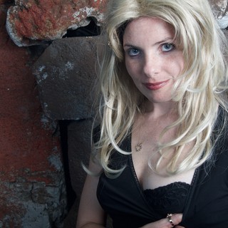 Blonde Woman Poses Against Rustic Brick Wall