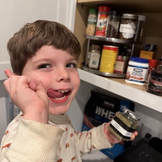 Young Boy Enjoys Snack Time in Kitchen Pantry