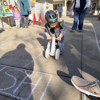 Young Child Racing on Scooter at Backyard Party