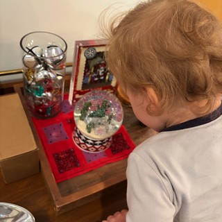 Young Child Discovering Christmas Snow Globe Wonders