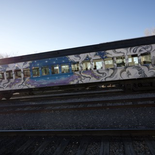 Graffiti-Adorned Train Cars on Railroad Tracks at Sunset