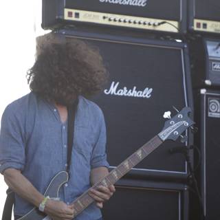 Curly-haired musician strums his guitar at FYF Festival