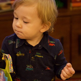 Toddler Examining Dark Green Vegetable with Curiosity