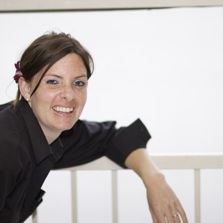 Smiling Woman Leaning on White Railing Portrait