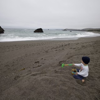 Young Child Playing Alone on Foggy Northern California Beach