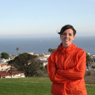 Woman in Orange Jacket Overlooking Coastal California Town