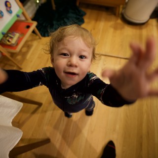 Toddler Reaching Up with Joy on Christmas Morning