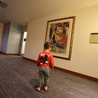 Child Admiring Vintage Film Poster in Hallway