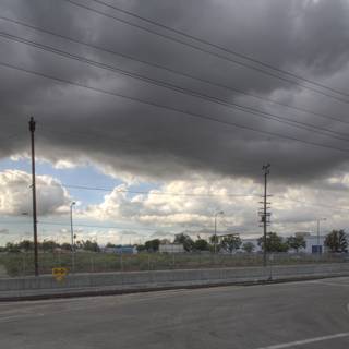 Cloudy Sky Over a Road with Power Lines