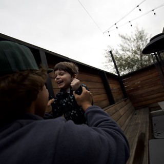 Joyful Moment Between Child and Adult on Outdoor Deck