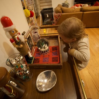Young Child Examining Christmas Snow Globe Display