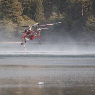 Helicopter aids in firefighting over a lake