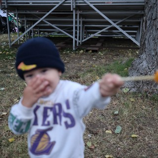 Young Lakers Fan Swings Stick at Autumn Bleachers