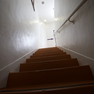 Ascending the Narrow Gallery Staircase in Bright Light