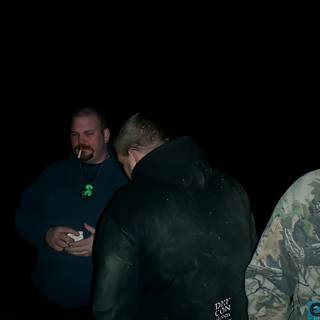 Three Men in Coats Holding Something in the Dark