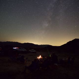 Under the Starry Night Sky Caption: Campers gather around a cozy campfire, under a dazzling night sky filled with stars and the Milky Way.