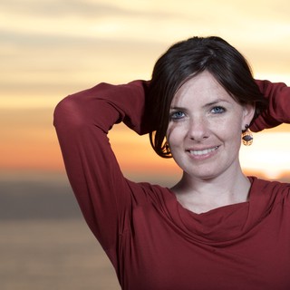 Radiant Woman Smiling at Sunset by the Sea