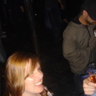 Young Woman Smiling at a Nighttime Social Gathering