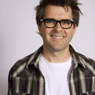 Smiling Man in Plaid Shirt and Glasses