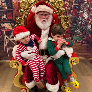 Two Boys Visit Santa in His Festive Workshop Throne