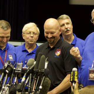 Blue-Shirted Men at Post-Interview Press Conference