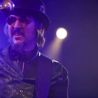 Les Claypool in Top Hat and Bow Tie Rocking the Guitar